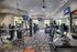 Modern fitness center with state-of-the-art gym equipment, bright lighting, and large windows offering scenic views.
