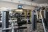Modern fitness center with state-of-the-art exercise machines, large mirrors, and flat-screen TVs in a spacious, well-lit environment.