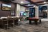 Elegant game room with a luxurious pool table, sleek bar seating, and vibrant entertainment screens, perfect for social gatherings.