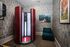 Chic tanning room featuring a modern red stand-up tanning booth, vibrant wallpaper, and stylish artwork for a relaxing experience.