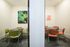 Inviting meeting space with vibrant artwork, featuring colorful chairs and round tables.