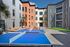 Vibrant modern apartment courtyard featuring colorful facades, lounge seating, and a blue ping pong table for recreation.