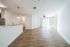 Bright and airy open-plan living space featuring modern wood flooring, a sleek kitchen with granite countertops, and abundant natural light from large windows.