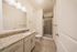 Elegant bathroom with granite countertop, spacious shower, and modern lighting.