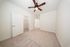 Bright and spacious bedroom with plush carpet, modern ceiling fan, and ample closet space.