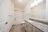 Bright, modern bathroom featuring a granite countertop, sleek cabinetry, and a pristine bathtub.
