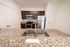 Modern kitchen with sleek granite countertops, stainless steel appliances, and rich wooden cabinetry.