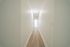 Bright and inviting hallway with elegant wooden flooring leading to a spacious, light-filled area.