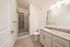 Contemporary bathroom with elegant granite countertop, modern fixtures, and a sleek glass shower enclosure.