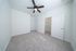 Bright and spacious bedroom with plush carpet, ceiling fan, and ample closet space.