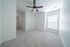 Bright and spacious bedroom featuring plush carpet, modern ceiling fan, and abundant natural light from large window.