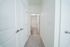 Inviting hallway with plush carpet leading to a bright, modern bathroom.