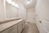 Elegant bathroom featuring a granite countertop, modern lighting, and a spacious bathtub.