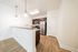Modern kitchen with stainless steel appliances, granite countertops, and elegant pendant lighting, featuring a bright and open design with hardwood flooring.