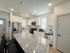 Modern kitchen with sleek stainless steel appliances, elegant granite countertops, and chic white cabinetry.