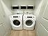 Sleek laundry area featuring modern front-loading washer and dryer with organized shelving.