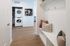 Charming entryway with cozy seating and stylish laundry area, featuring stacked washer and dryer in a modern apartment.