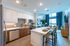 Modern open-concept kitchen and living area with sleek cabinetry, stylish backsplash, and elegant bar seating, offering a welcoming atmosphere with natural light and city views.
