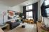 Chic modern living room with a cozy sectional sofa, elegant decor, and large windows offering abundant natural light.