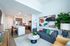 Contemporary open-plan living space with a sleek kitchen, modern furniture, and vibrant artwork, offering a welcoming and stylish environment.