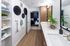 Modern bathroom with sleek double sinks, stylish wall decor, and wooden accents leading to a cozy bedroom.