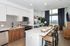 Modern open-concept kitchen and living area with sleek cabinetry, elegant island seating, and large windows offering stunning views.