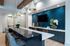 Chic modern kitchen with elegant marble countertop, sleek pendant lighting, and stylish blue tile backsplash.