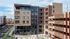 Modern urban apartment complex showcasing sleek architecture, plentiful windows, and a welcoming courtyard.