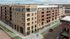 Modern urban apartment building with sleek design, large windows, and convenient location on a stylish street corner.