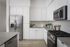 Modern kitchen with sleek stainless steel appliances, pristine white cabinets, and elegant countertops, offering a bright and inviting space.