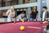 Vibrant community apartment features a modern pool table with group of friends enjoying a leisure game in a stylish lounge area.