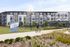 Modern apartment complex with balconies, surrounded by lush landscaping and a bike-friendly path at Atlas Eastside.
