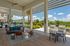 Luxurious outdoor lounge area with stylish furniture, a scenic garden view, and modern grill stations under a sleek pergola design.
