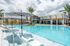 Luxurious resort-style pool area with chic sun loungers, modern architecture, and lush landscaping, perfect for relaxation and leisure.