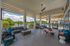 Spacious outdoor lounge with modern seating, overlooking a tranquil pool and lush greenery, perfect for relaxation.