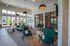 Luxurious apartment lounge with modern decor, featuring teal armchairs, a stylish sofa, and abundant natural light through large windows.