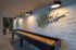 Modern game room with a sleek shuffleboard table under stylish lighting, surrounded by vibrant artwork and chic decor.