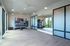 Sleek and modern fitness room with floor-to-ceiling mirrors, abundant natural light, and well-organized equipment. Ideal for energetic workouts.