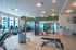 Modern fitness center with state-of-the-art equipment, bright lighting, and large windows offering a vibrant workout environment.