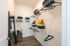 Spacious walk-in closet with modern wire shelving, stylish storage bins, and ample hanger space, featuring a chic hardwood floor and cozy decorative pillows.