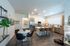 Modern kitchen and dining area with sleek design, featuring a spacious island, elegant bar stools, and cozy dining setup.
