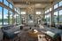 Luxurious and spacious living room with floor-to-ceiling windows, modern decor, and a stunning view of greenery.