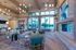 Luxurious open-concept living room featuring modern seating, vibrant artwork, and large windows with stunning views.