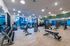Bright, modern gym with state-of-the-art equipment, large windows, and stylish wood flooring.