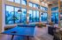 Modern lounge area featuring a stylish ping pong table, plush seating, and large windows with serene outdoor views.
