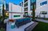 Chic outdoor lounge area featuring modern seating, ambient string lights, and a sleek fireplace, perfect for entertaining in a contemporary apartment setting.