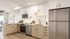 Modern kitchen with sleek appliances, elegant wooden cabinets, and a stylish breakfast bar in a bright, open living space.