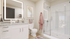 Modern bathroom with illuminated mirror, sleek vanity, glass shower, and chic decor in a bright, elegant space.