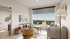 Modern apartment living room with large window view, stylish furniture, and cozy decor.