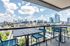 Luxurious apartment balcony offering stunning cityscape views with modern outdoor seating.